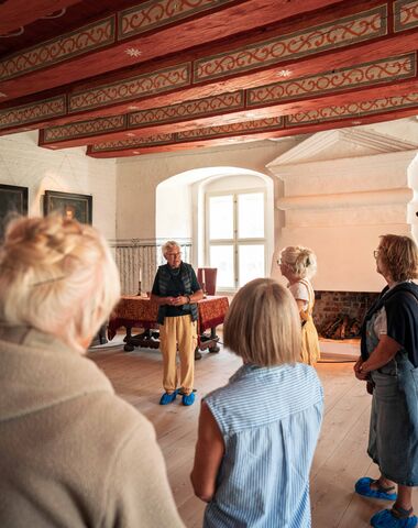 En rundviser fortæller for besøgende på Gammel Estrup