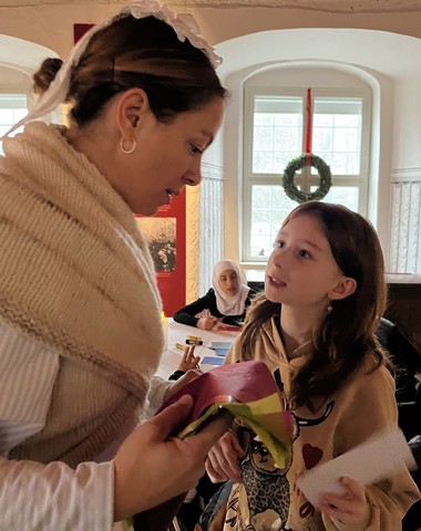 Stuepige viser elev hvordan man klipper julepynt