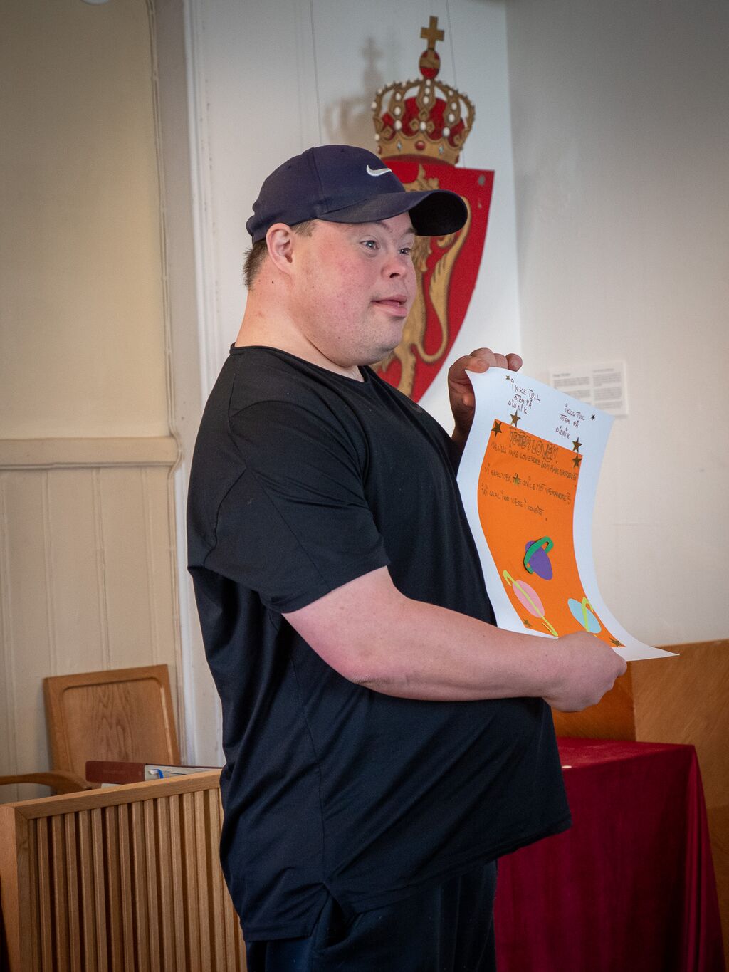 Mand med udviklingshandicap fremviser et ark papir